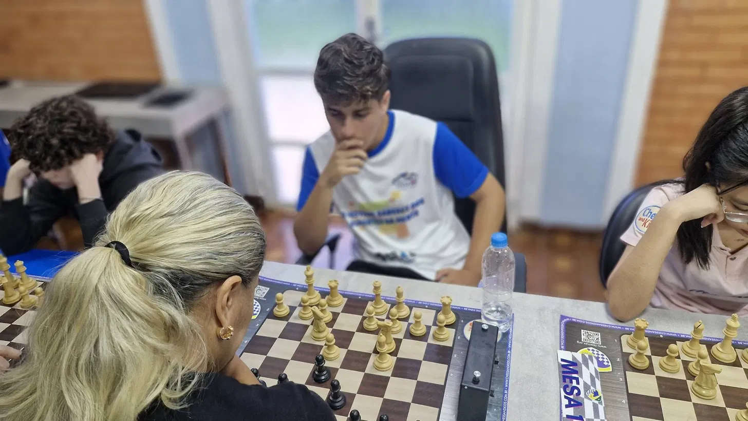 Estudantes disputando partida de xadrez em torneio CBXE